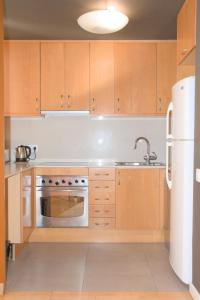 a kitchen with wooden cabinets and a stainless steel appliance at SWEET BCN Rambla 48 in Barcelona