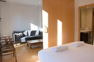 a bedroom with a bed and a living room with a couch at SWEET BCN Rambla 48 in Barcelona