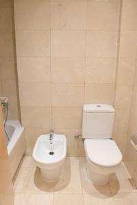 a bathroom with a white toilet and a sink at SWEET BCN Rambla 48 in Barcelona