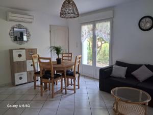 a living room with a table and chairs and a couch at Appartement plain-pied in Piolenc