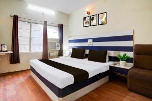 une chambre avec un grand lit et un canapé dans l'établissement Hotel O Lashkar Gwalior, à Gwalior