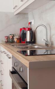 a kitchen counter with a sink and a stove at Galazio suites 1 in Salamís