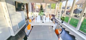 a room with a long table with chairs and windows at Duddingston 9 Bedroom House - Edinburgh in Edinburgh