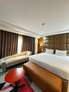 pokój hotelowy z dużym łóżkiem i krzesłem w obiekcie Golden Tulip Hotel Port Harcourt -GTPH w mieście Port Harcourt