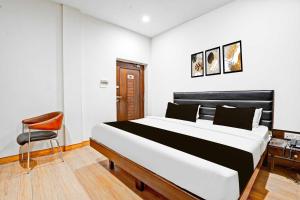 una camera da letto con un letto grande e una sedia di Hotel O Gurudwara Square a Gwalior
