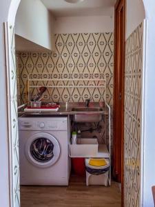 een kleine keuken met een wasmachine en een wastafel bij Centralissimo a Gaeta - CasAurora P2 in Gaeta
