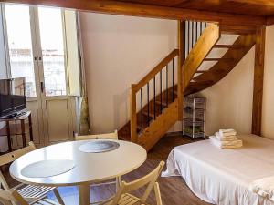 een kamer met een tafel, een bed en een trap bij Centralissimo a Gaeta - CasAurora P2 in Gaeta