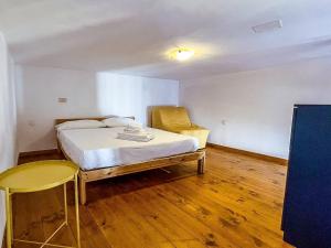 een kleine slaapkamer met een bed en een stoel bij Centralissimo a Gaeta - CasAurora P2 in Gaeta +7 foto's