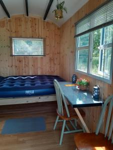 a bed in a room with a table and chairs at St Mullins Glamping Hut,R95T3CT in Saint Mullins