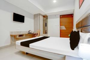 瓜廖尔Hotel O Jiwaji Chowk Lashkar的卧室里有一张白色的大床和一台电视