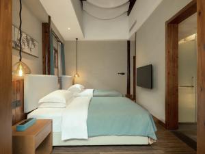 Un pat sau paturi într-o cameră la Hidden Moisture and Return to Simplicity Homestay in Mount Huangshan