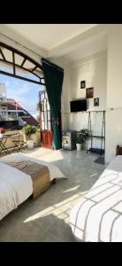 a bedroom with two beds and a large window at Hotel Ngọc My in Phan Thiet