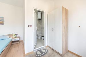 a small bedroom with a mirror and a bed at Sea Breeze Vacation House I BBQ & Jacuzzi in Ezerets