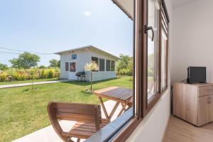 a room with a window and a table and a television at Sea Breeze Vacation House I BBQ & Jacuzzi in Ezerets