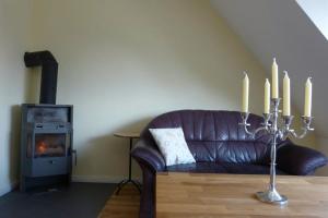 ein Wohnzimmer mit einem Ledersofa und einem Kamin in der Unterkunft Kamminke - Uns lütt Hus in Kamminke