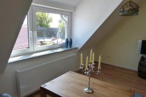 Zimmer mit einem Tisch mit Kerzen und einem Fenster in der Unterkunft Kamminke - Uns lütt Hus in Kamminke