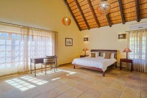 a bedroom with a bed and a desk in a room at Stunning Bushveld Villa 84 in Warmbaths