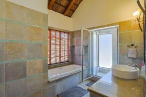 a bathroom with a tub and a sink and a shower at Stunning Bushveld Villa 84 in Warmbaths +46 photos