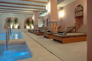 a pool in a hotel with couches and a swimming pool at Nomad Hotel & Spa Altea in Altea