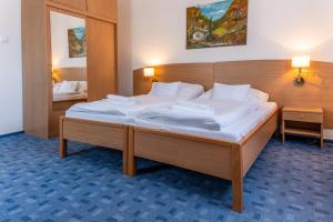 a bedroom with a large bed with white sheets at Levendula Resort és Rendezvényközpont in Bogács