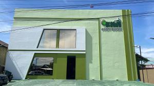 un edificio verde y blanco con un cartel en él en Kiwi Guest House Palangka Raya, en Palangkaraya