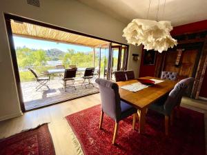 a dining room with a table and chairs and a large window at Bryan's View in Windhoek