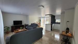 a living room with a blue couch and a kitchen at Casa completa con muchas comodidades in Paysandú
