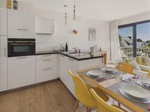 a kitchen and dining room with a table and yellow chairs at 300 m de la plage - Appart pour 4 avec balcon in Beg-Meil