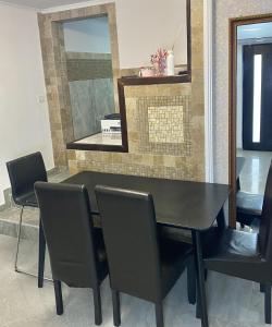 a black dining room table with chairs and a mirror at Casa Miru in Mangalia +18 photos