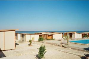 a house with a swimming pool next to the ocean at Lac Moeris in ‘Ezbet el-Râ‘l el-Kharâba