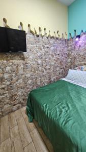 パレルモにあるCasa Porta Nuova 1989のレンガの壁のベッドルーム(ベッド1台、テレビ付)