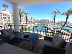 a balcony with a table and chairs and a view of a harbor at Puerto Duquesa fancy condo overlooking Marina in Manilva