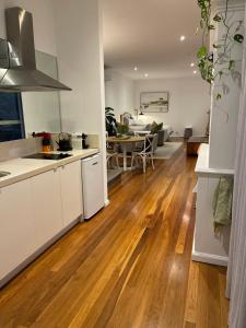 Il comprend une cuisine et un salon avec du parquet. dans l'établissement River Retreat, à Grays Point