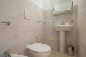 a bathroom with a white toilet and a sink at Dammuso Ignazio in Lampedusa