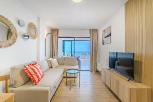 a living room with a couch and a tv at Stunning cliffs and ocean view in Los Gigantes in Acantilado de los Gigantes