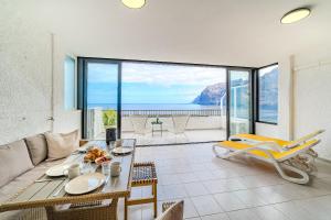 a living room with a couch and a table at Stunning cliffs and ocean view in Los Gigantes in Acantilado de los Gigantes