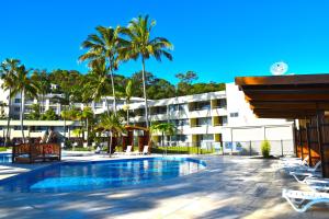 a resort with a swimming pool and palm trees at Villa 15 Tangalooma Resort in Tangalooma