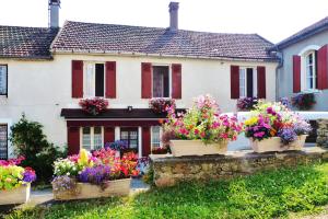 une maison avec des fleurs devant elle dans l'établissement La Maison de Cure, à Domecy-sur-Cure