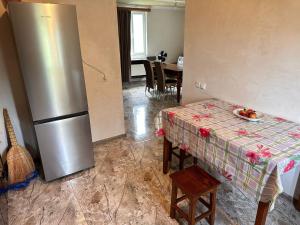 a kitchen with a table and a stainless steel refrigerator at The heart of Sachkhere in Itʼkhvisi +31 photos