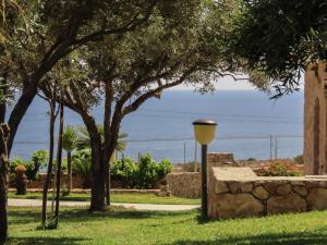 a street light in a park with trees and the ocean at Dammuso Ignazio in Lampedusa