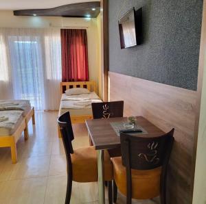 a dining room with a table and chairs and a bedroom at Just Joy Apartman in Vrdnik