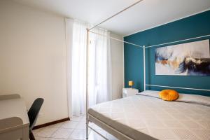 a bedroom with a bed with a blue wall at Residenza al Campanile Lake & Mountain Free parking in Porto Ceresio