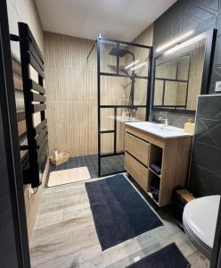 a bathroom with a sink and a shower at Love Room Luxe and Spa - Sauna in Domérat