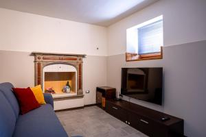 a living room with a blue couch and a flat screen tv at Residenza al Campanile Lake & Mountain Free parking in Porto Ceresio