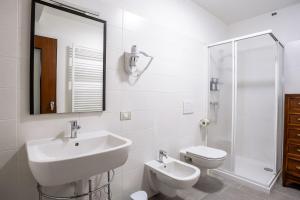 a white bathroom with a sink and a toilet at Residenza al Campanile Lake & Mountain Free parking in Porto Ceresio +27 photos