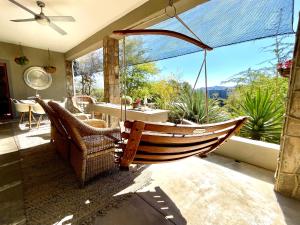 a porch with a hammock and a table and chairs at Bryan's View in Windhoek