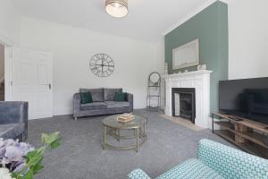 a living room with a couch and a tv at Spacious! 6BR in Beach Road in South Shields