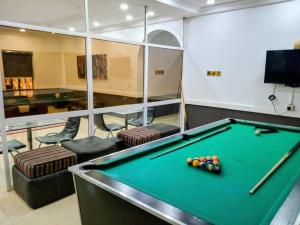 a billiard room with a pool table in a room at The Bougainville Apartments in Asaba