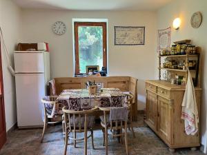 a kitchen with a table with chairs and a refrigerator at Two Hearts Kishután in Kishuta