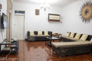 a living room with two couches and a tv at Villa Liwonde - Cottage in Liwonde